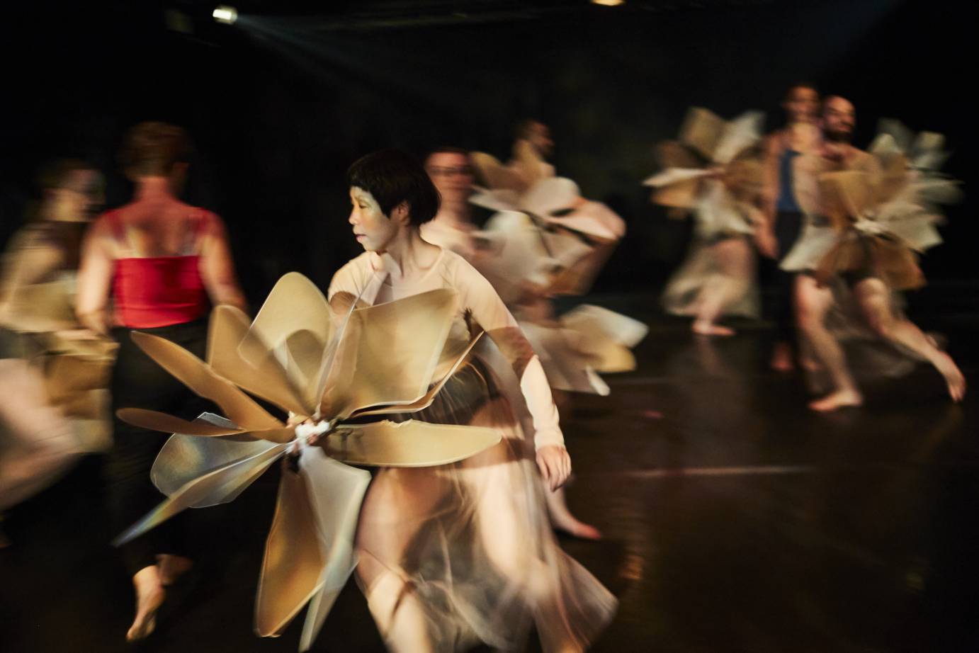 Dancers hold pinwheels as they run